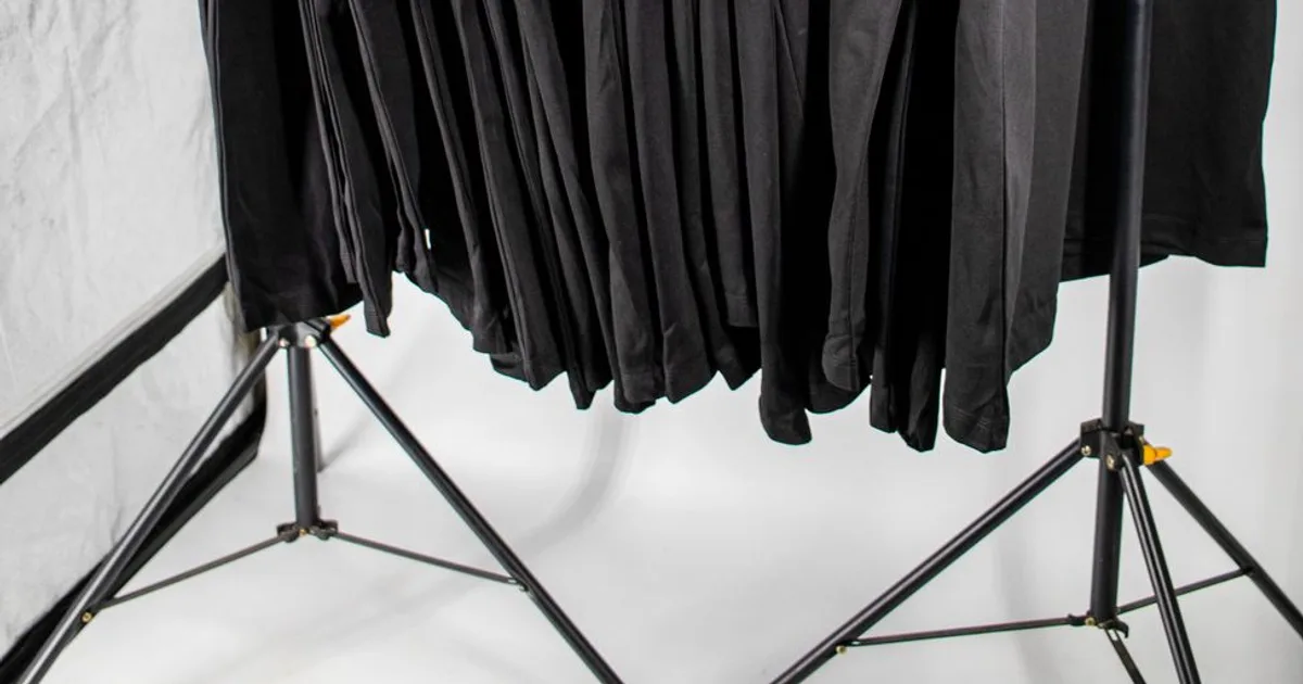 T-shirts noirs suspendus sur un portant dans un studio textile